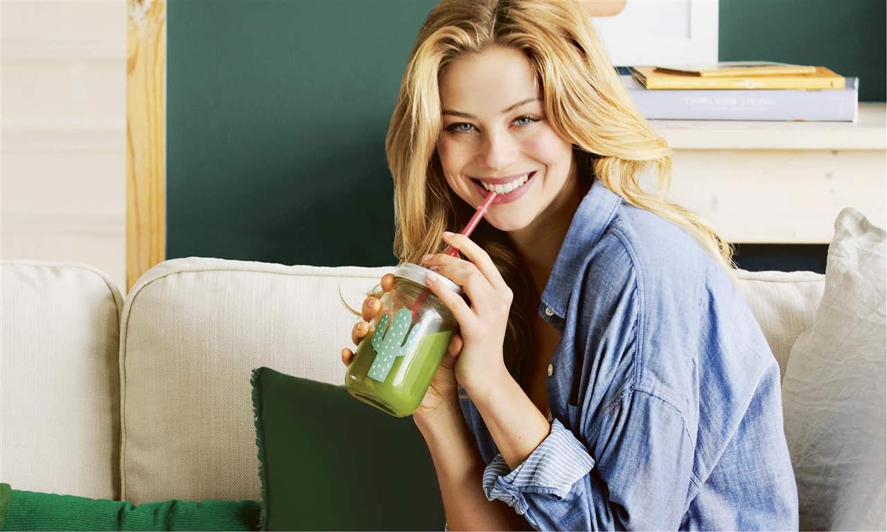 mujer tomando smoothie zumo batido verde