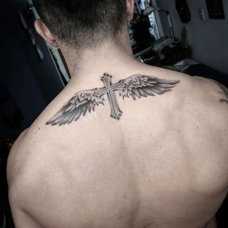 Tatuajes de alas con significado: con cruz
